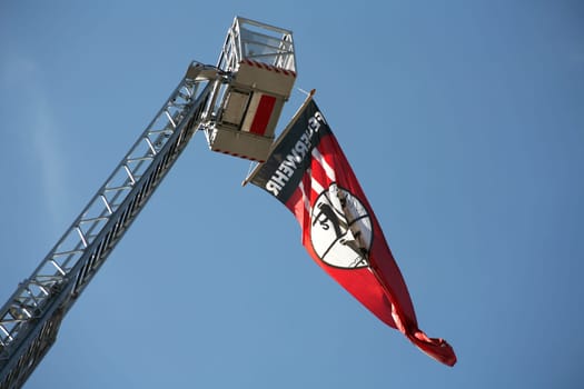 Fire brigade flag at the top of an extended turntable ladder