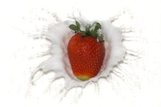Strawberry falls into milk