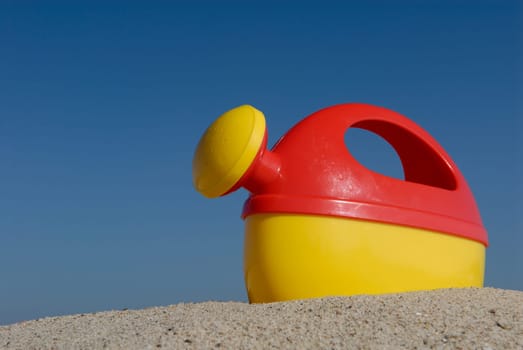 Watering can on the beach.