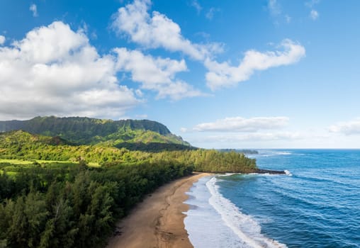 Aerial panoramic image off the coast over Lumaha'i beach on Hawaiian island of Kauai with Na Pali mountains behind. Taken at dawn