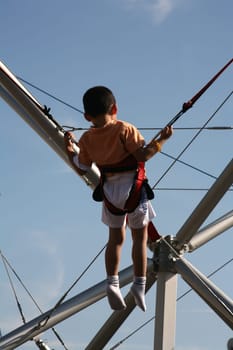 Little boy on a bungee trampoline at a folk festival