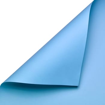 A clean and minimalist composition featuring a sheet of smooth blue paper curled at the corner. The vibrant color and elegant fold create a dynamic yet simple visual element