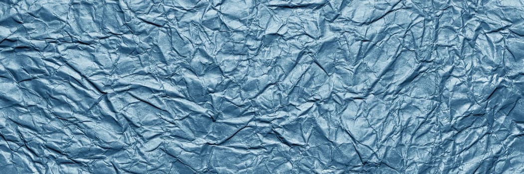 A textured dark blue crumpled paper background with natural creases and folds. Ideal for design projects, digital graphics, or creative presentations requiring a vibrant, Long banner