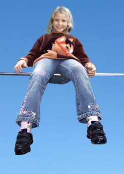 Girl 6 years sitting on gymnastics bar