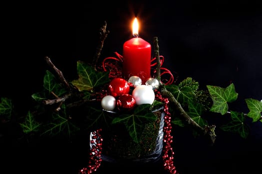 red candle with ivy across
