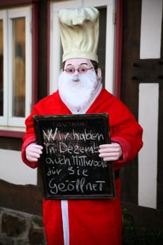 Chef figure dressed as Santa Claus in front of a restaurant