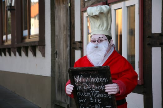 Chef figure dressed as Santa Claus in front of a restaurant
