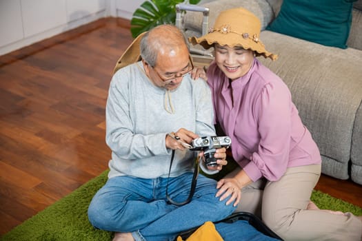 Travel and tourism. Asian couple old senior marry retired couple smiling taking photo by camera during luggage suitcase arranging for travel, Happy mature retired couple photography weekend holiday