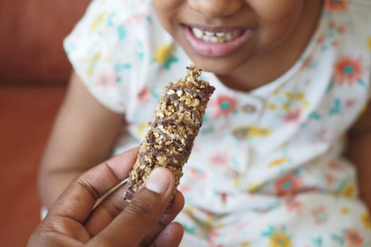 child eating dark chocolate close up .