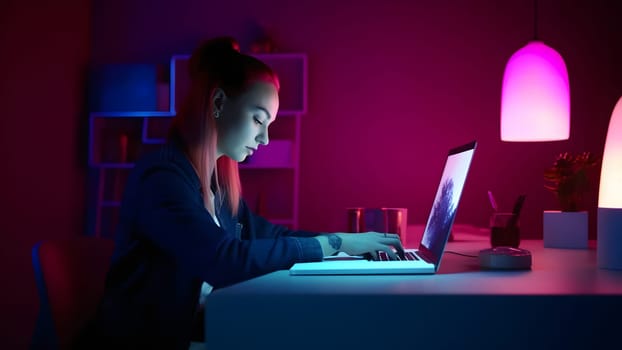 designer girl sitting at the table in front of laptop in home office at evening. Neural network generated in May 2023. Not based on any actual person, scene or pattern.