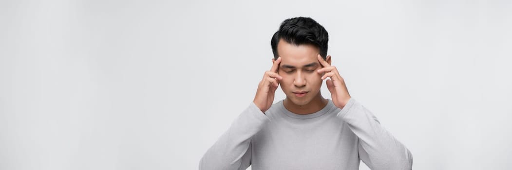Handsome asian man with hand on head, headache because stress. suffering migraine.