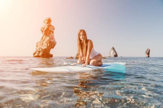 Close up shot of happy young caucasian woman looking at camera and smiling. Cute woman portrait in bikini posing on a volcanic rock high above the sea