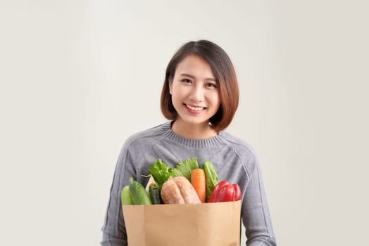 healthy lifestyle with green vegan food. young woman hold shopping bag with vegetables.