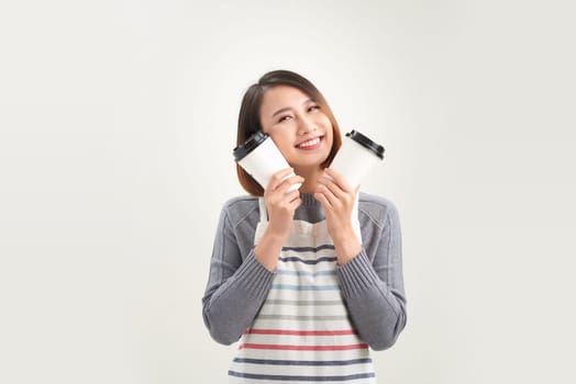 young woman in apron holds two takeaway paper cup isolated over white background