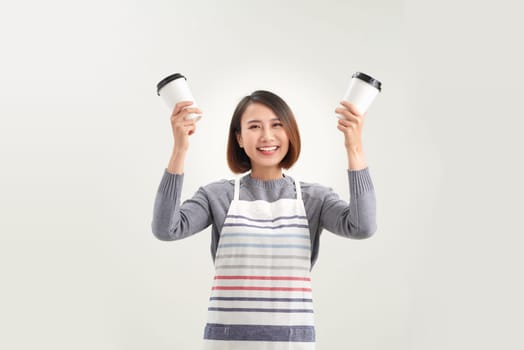 Young asian entrepreneur woman in apron with hand holding cup of coffee isolated on white background