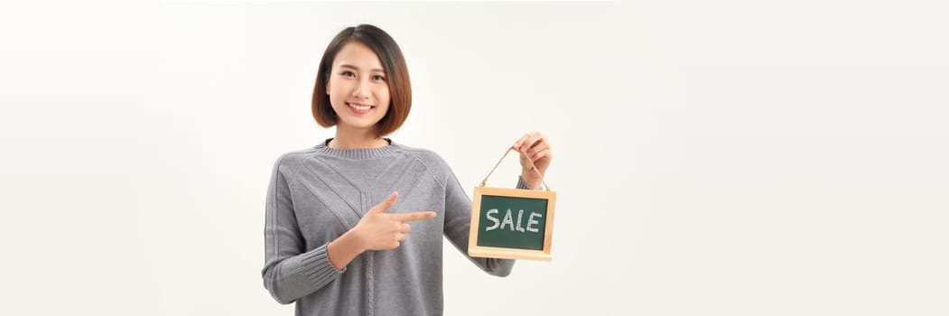 Beautiful asian woman in barista apron holding SALE word blackboard sign on white background