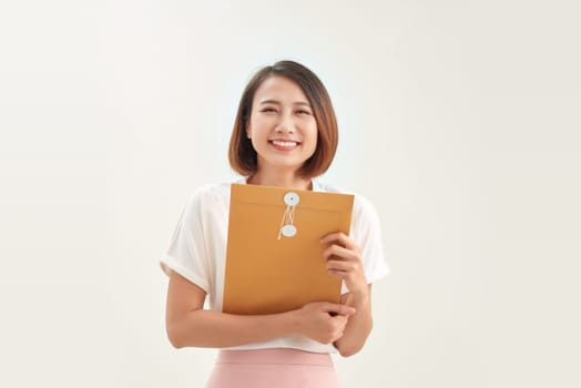 business woman holding brown paper envelopes in office 