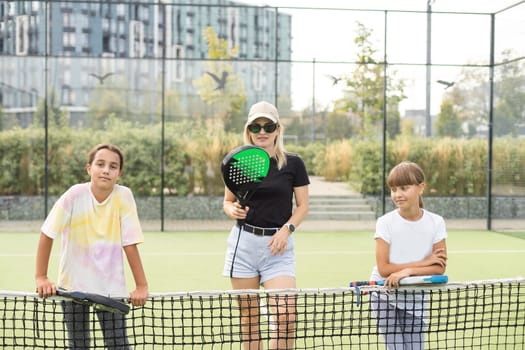 mother and daughters playing padel outdoor. High quality photo