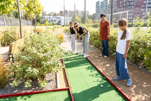 mini golf in nature. mini golf player putting golf ball into the hole on bumpy green lane. High quality photo
