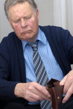 Pensioner looks into the empty wallet