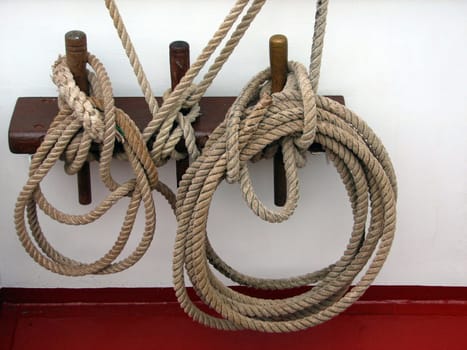 A small nail bank on a tall ship.  "A covering nail is a short,usually rounded at the top and tapered at the bottom,wooden stick,which was formerly used on sailing ships to cover the weaker ropes of the running goods,i.e. f"