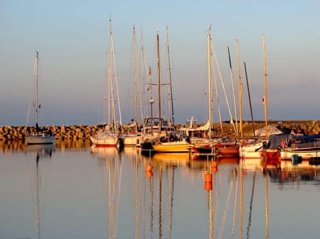 Evening atmosphere in the harbour of Simrishamn/west coast of Sweden. Very popular and therefore always well visited and yet every ship still finds a place,even the sailor who enters the harbor late. They move closer together and welcome him.