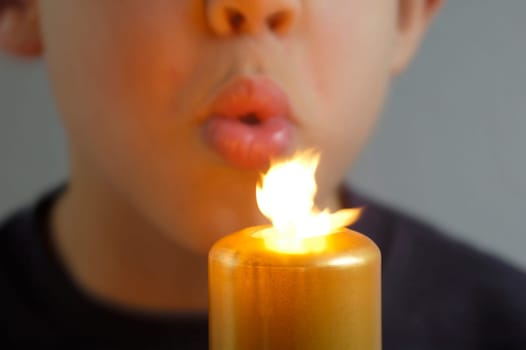 Boy blows out a candle