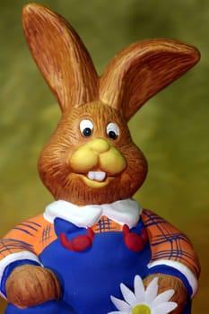 Funny sitting figure a bunny with blue dungarees