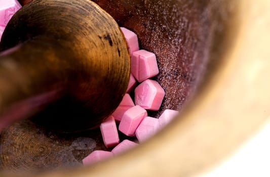 Pink tablets in a mortar