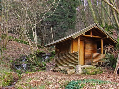 Forest hut by the stream