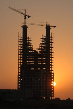 Silhouette of a high-rise building under construction in Jeddah,Saudi Arabia,at sunset.