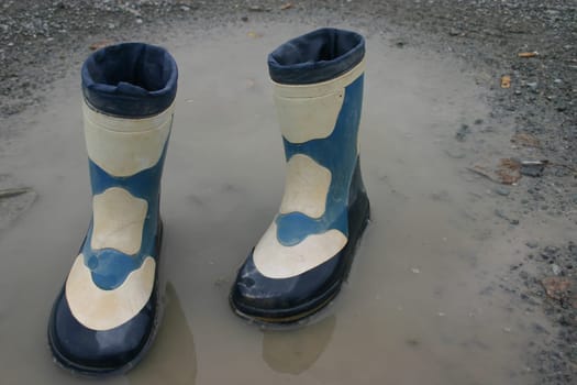Rubber boots in puddle