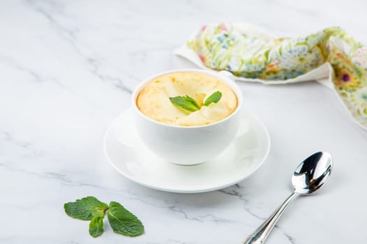 cup of coffee with foam and a sprig of mint