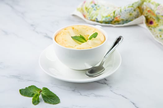 cup of coffee with foam and a sprig of mint