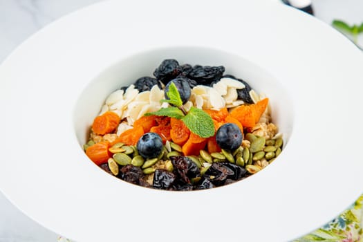deep plate with cereals, berries, pistachios, dried apricots and raisins