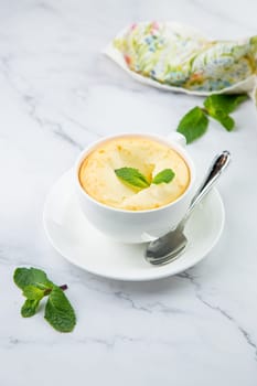 cup of coffee with foam and a sprig of mint