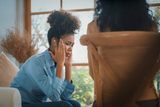 Sad PTSD woman patient in crucial therapy for mental health with psychologist, depression or grief after life failure. Frustrated trauma young woman talking to a psychologist about emotion in clinic