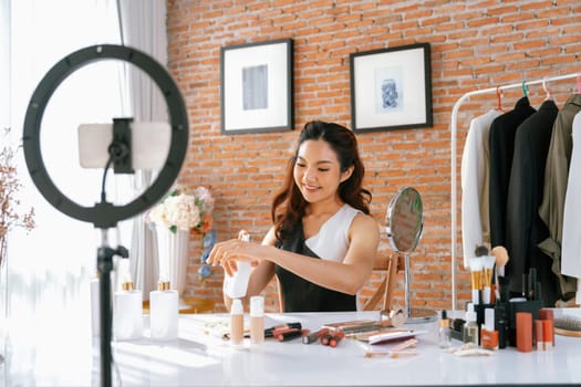 Woman influencer shoot live streaming vlog video review makeup uttermost social media or blog. Happy young girl with cosmetics studio lighting for marketing recording session broadcasting online.