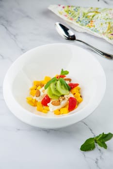 fruit salad with kiwi, strawberries, mango and nuts