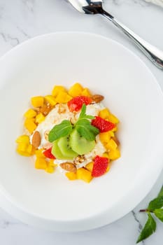 fruit salad with kiwi, strawberries, mango and nuts