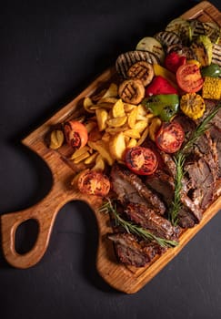 fried pieces of steak with vegetables on the grill