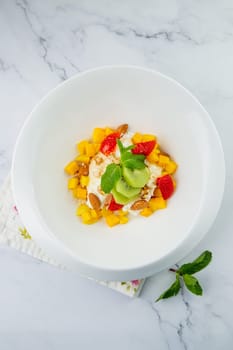 fruit salad with kiwi, strawberries, mango and nuts