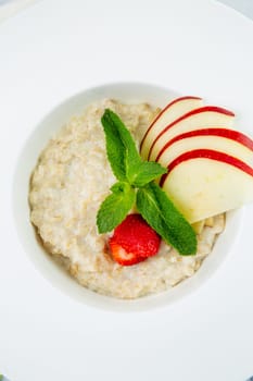 oatmeal with thinly sliced ​​apples, strawberries and mint