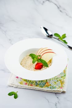 oatmeal with thinly sliced ​​apples, strawberries and mint