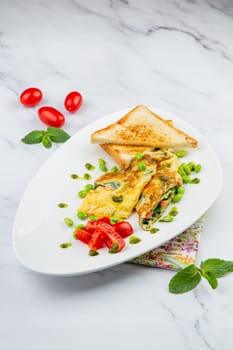 Breakfast of eggs and vegetables with cherry tomatoes and slices of bread