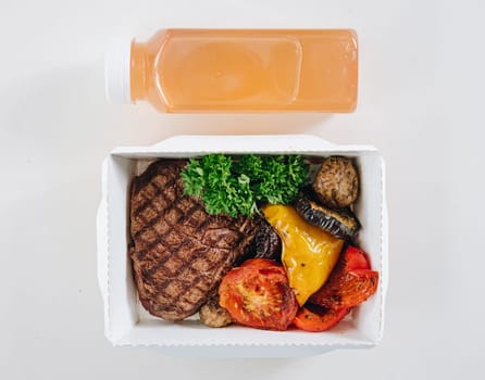 food in containers. proper nutrition, daily diet, weight loss. drink, veal steak with grilled vegetables.