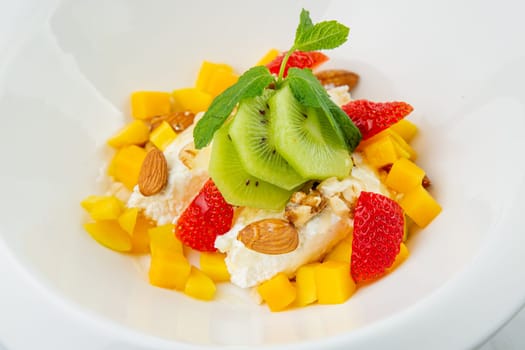 fruit salad with kiwi, strawberries, mango and nuts