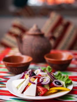 Vegetable slicing in Georgian style - tomatoes, cucumbers, greens, Bulgarian pepper, cheese, onion. Asian style. High quality photo