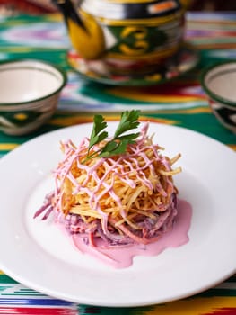 Capercaillie nest salad made of beets, pie potatoes, markovi and greens, topped with mayonnaise. Asian style. High quality photo