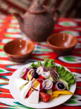 Vegetable slicing in Georgian style - tomatoes, cucumbers, greens, Bulgarian pepper, cheese, onion. Asian style. High quality photo